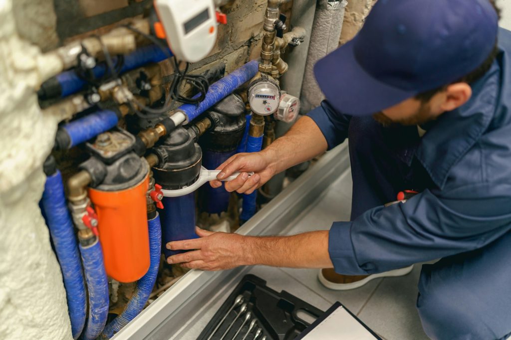 Professional plumber repairing water supply system at home uses a special tools