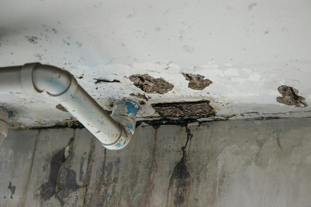 Sewer pipe leak bad old plumbing water leakage inside the concrete wall rusty damaged building